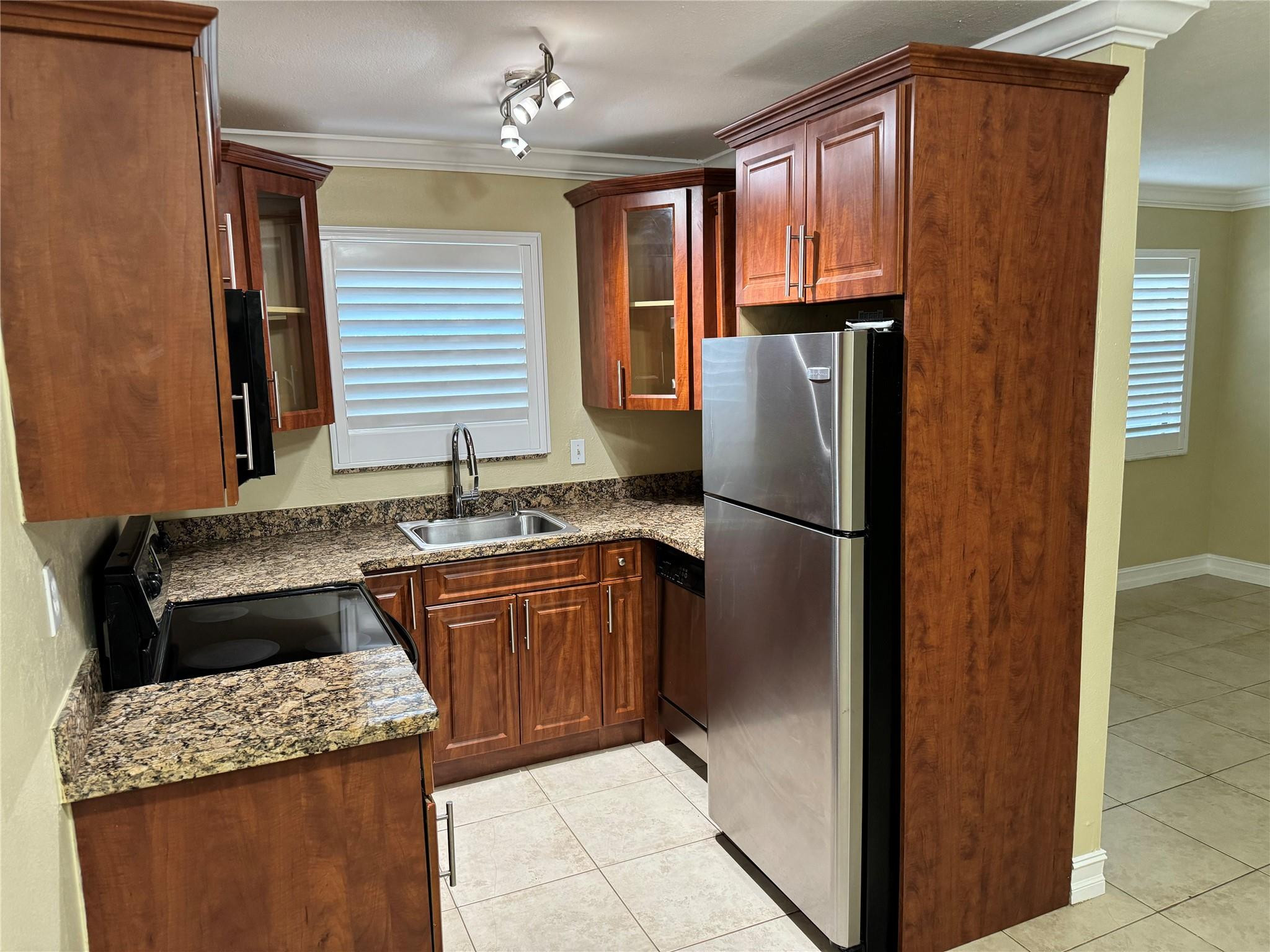 1925 Madison Street, Unit 21 Hollywood, FL 33020 - Photo 3 of 10 a kitchen with granite countertop stainless steel appliances a refrigerator and a sink