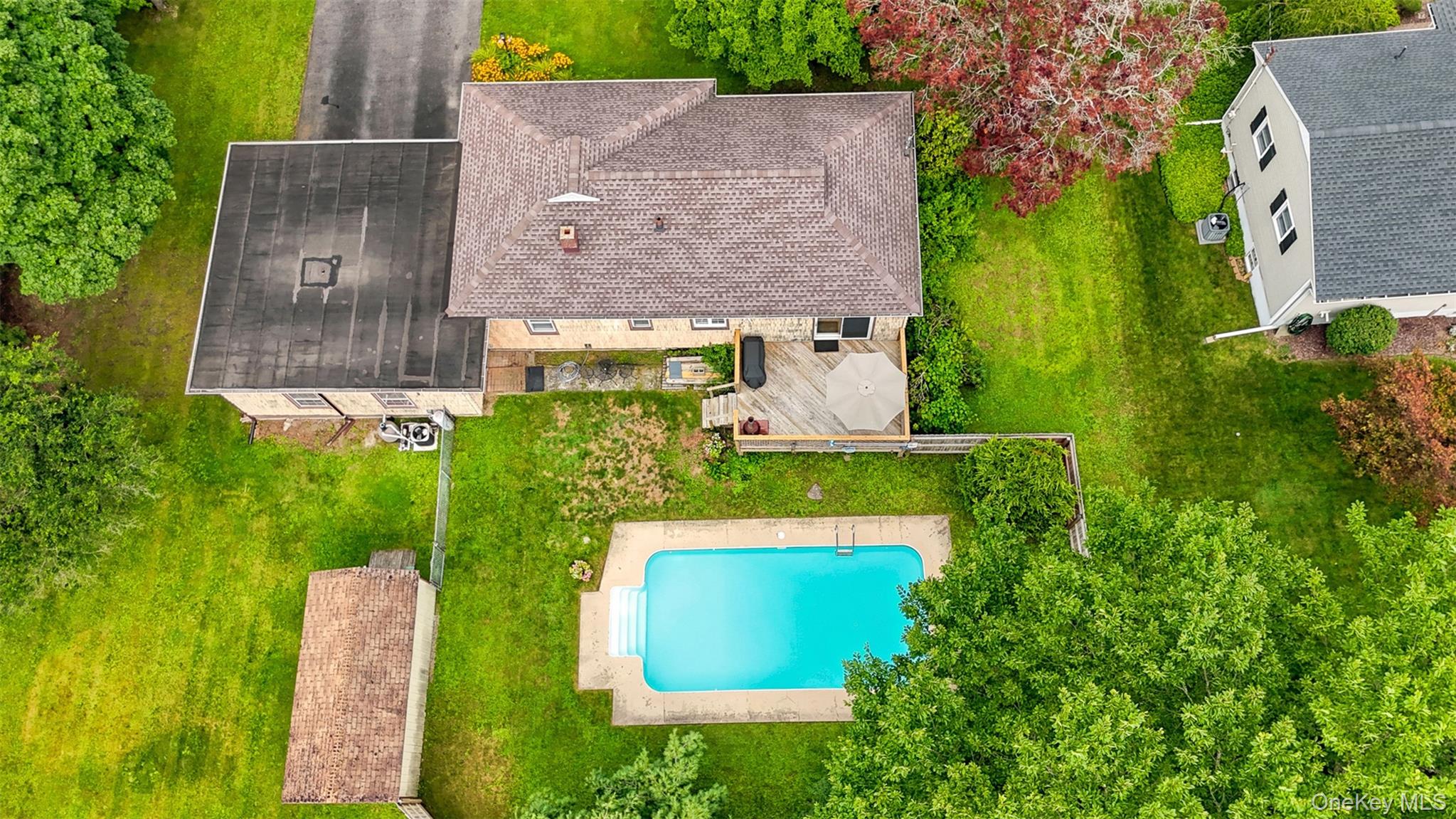 48 Ryerson Road New Hampton, NY 10958 - Photo 3 of 33 Expansive property featuring a rectangular in-ground swimming pool with steps, a large wood deck, and a detached structure with a flat roof