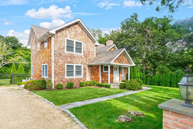 a front view of a house with a yard and potted plants