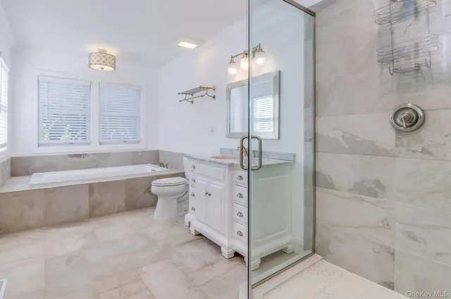 a spacious bathroom with a bathtub a toilet and a shower