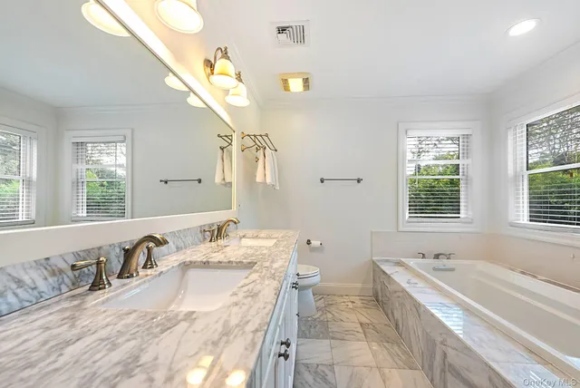a spacious bathroom with a granite countertop tub sink and mirror