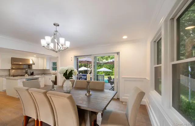 a view of a dining room with furniture a livingroom and chandelier