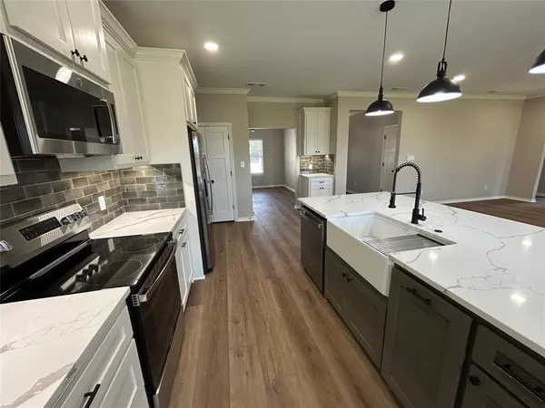 a kitchen with stainless steel appliances granite countertop a sink a refrigerator and a stove