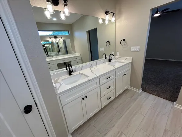 a spacious bathroom with a double vanity sink and mirror