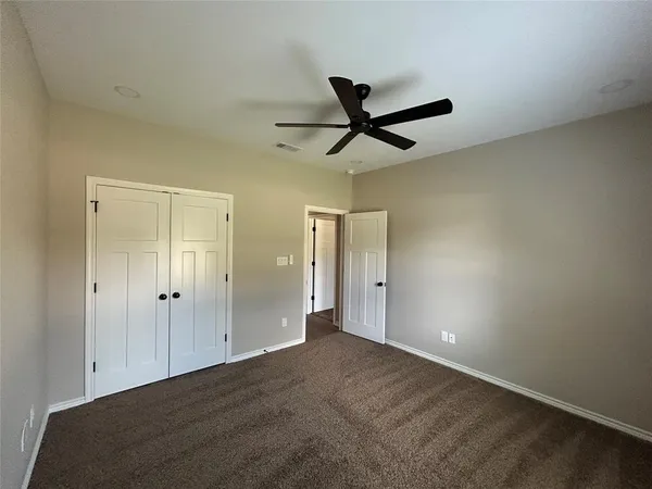 an empty room with a ceiling fan and a window