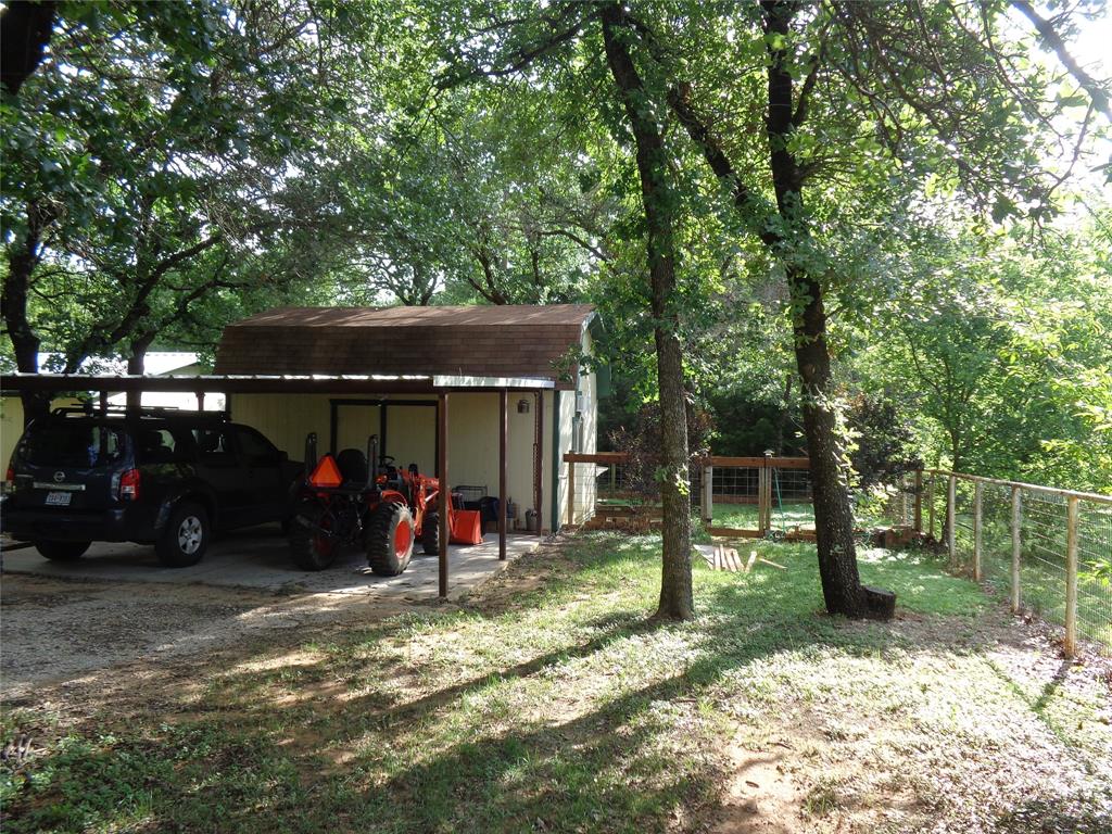 5525 Cedar Oaks Road Grandview, TX 76050 - Photo 23 of 40 Detached carport structure featuring a shingled roof and integrated storage building