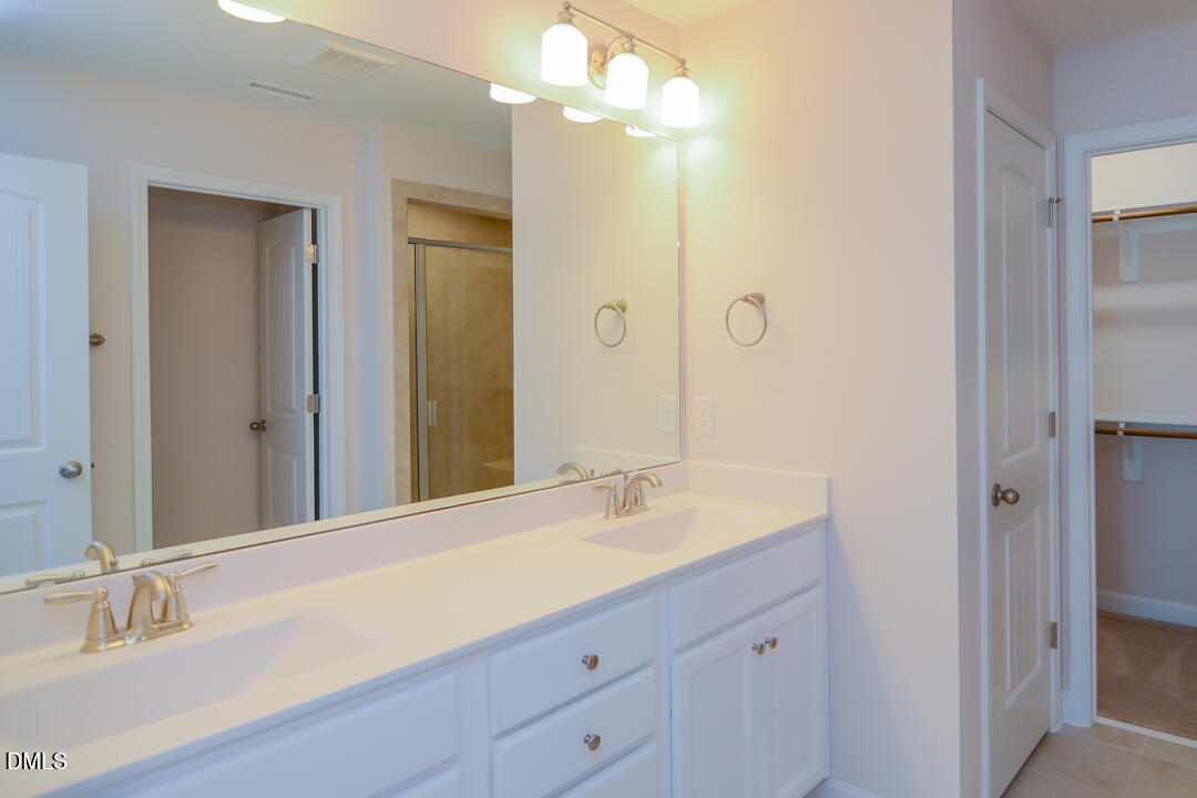 1803 Grandmaster Way Wake Forest, NC 27587 - Photo 13 of 26 a bathroom with a sink vanity and a mirror