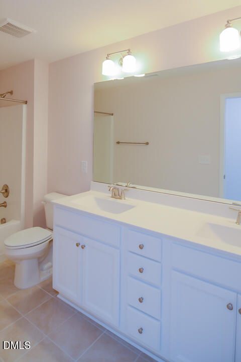 1803 Grandmaster Way Wake Forest, NC 27587 - Photo 18 of 26 a bathroom with a toilet a sink a vanity and mirror