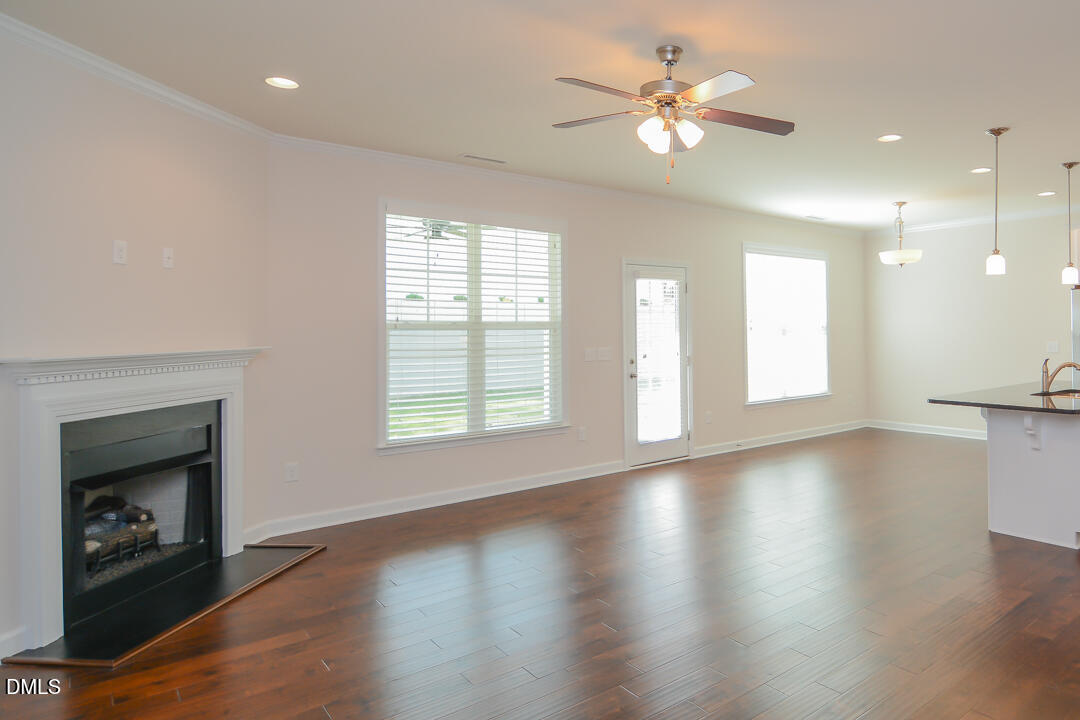 1803 Grandmaster Way Wake Forest, NC 27587 - Photo 7 of 26 an empty room with windows fireplace and a kitchen view