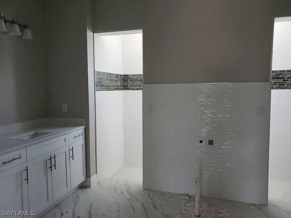 2715 50th Street Southwest Lehigh Acres, FL 33976 - Photo 12 of 16 a bathroom with a granite countertop sink and shower