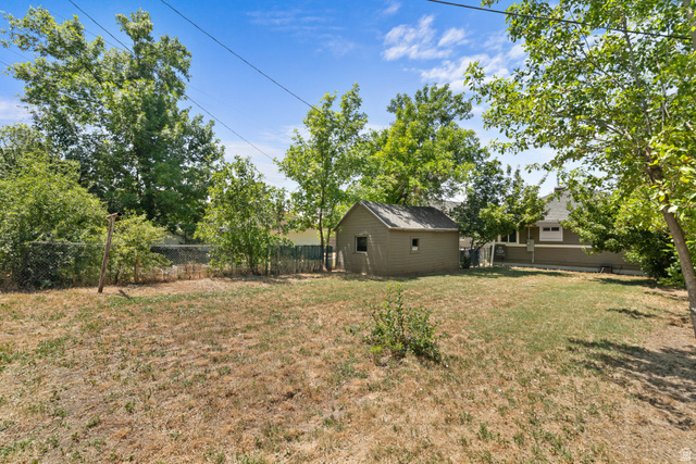 2862 Fowler Avenue Ogden, UT 84403 - Photo 7 of 23 Expansive grassy area with mature perimeter trees and a chain-link fence