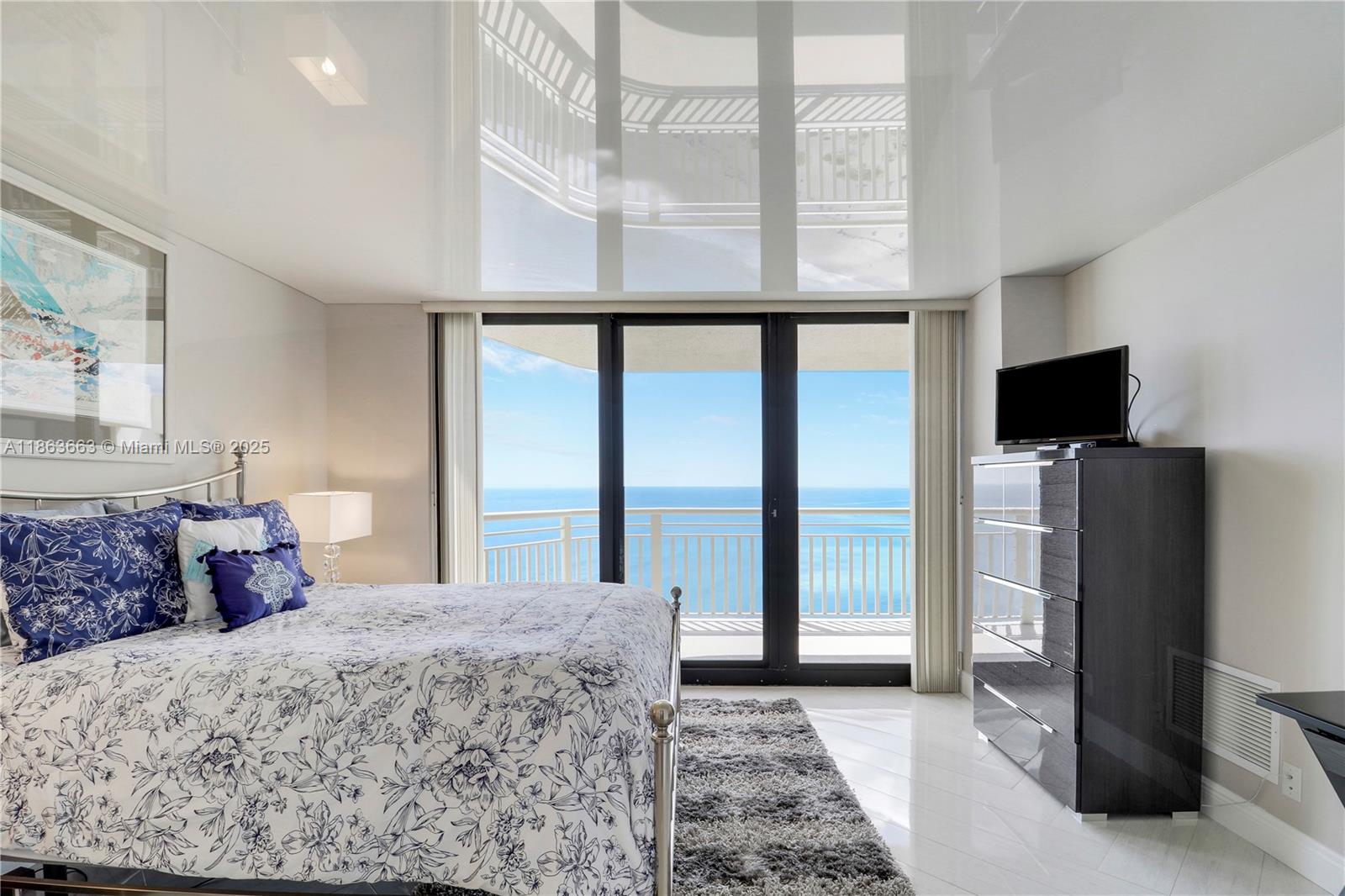 3000 North Ocean Drive, Unit PHD Singer Island, FL 33404 - Photo 50 of 97 a bedroom with a bed a tv on wall and a large window