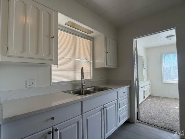 a kitchen with granite countertop a sink and cabinets