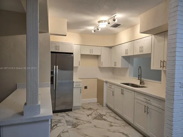 a kitchen with a sink and refrigerator