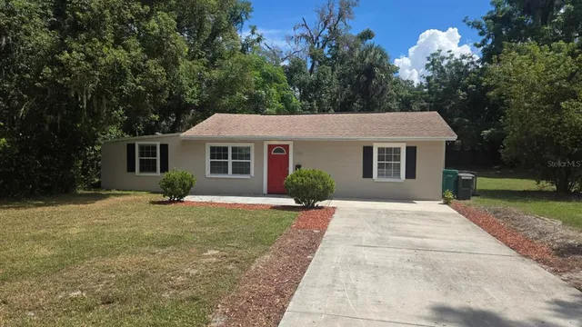 a front view of a house with a yard and trees