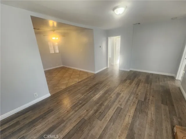 an empty room with wooden floor and mirror