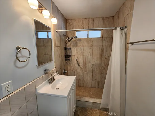 a bathroom with a shower sink and mirror