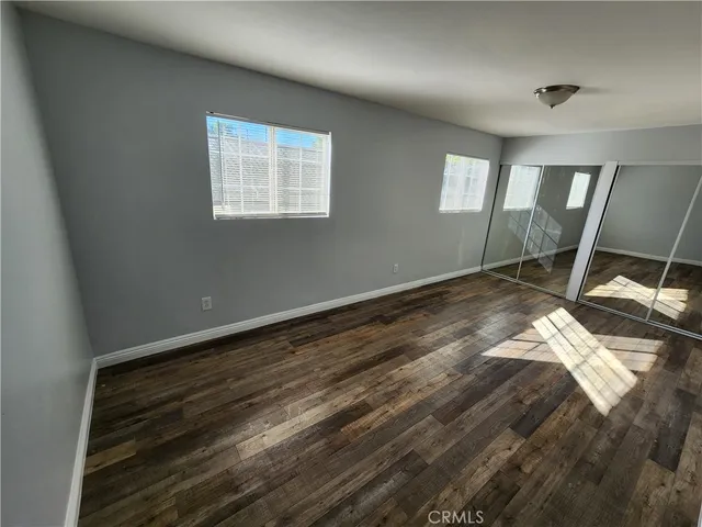 a view of a room with wooden floor fan and windows