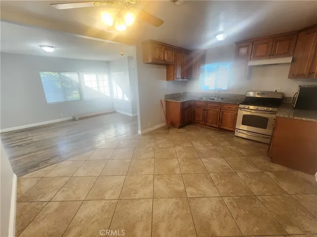 a kitchen with stainless steel appliances a stove a sink a counter top space and cabinets