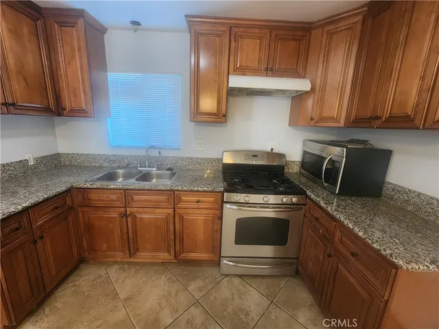 a kitchen with granite countertop cabinets stainless steel appliances and a sink