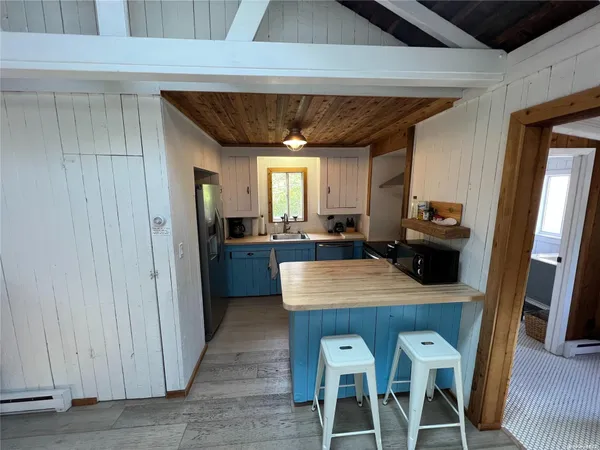 a kitchen with stainless steel appliances granite countertop a table chairs and a refrigerator