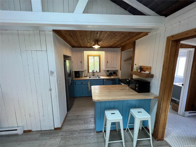 a kitchen with stainless steel appliances granite countertop a table chairs and a refrigerator