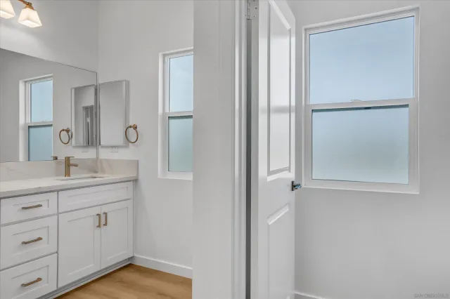 a bathroom with a granite countertop sink mirror and vanity