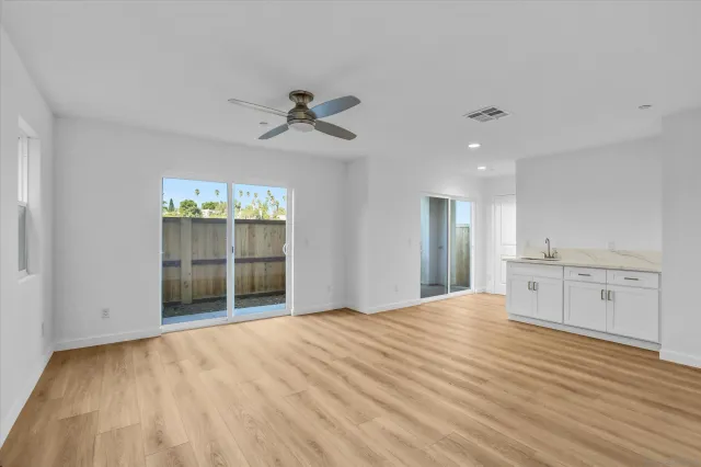 a view of empty room with cabinet and wooden floor