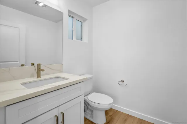 a bathroom with a sink a toilet and mirror