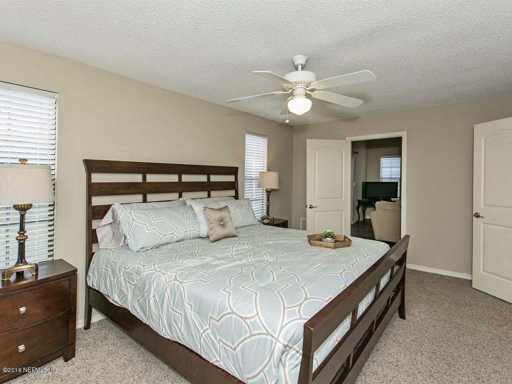 12788 Attrill Road Jacksonville, FL 32258 - Photo 9 of 20 a bedroom with a bed and a chandelier