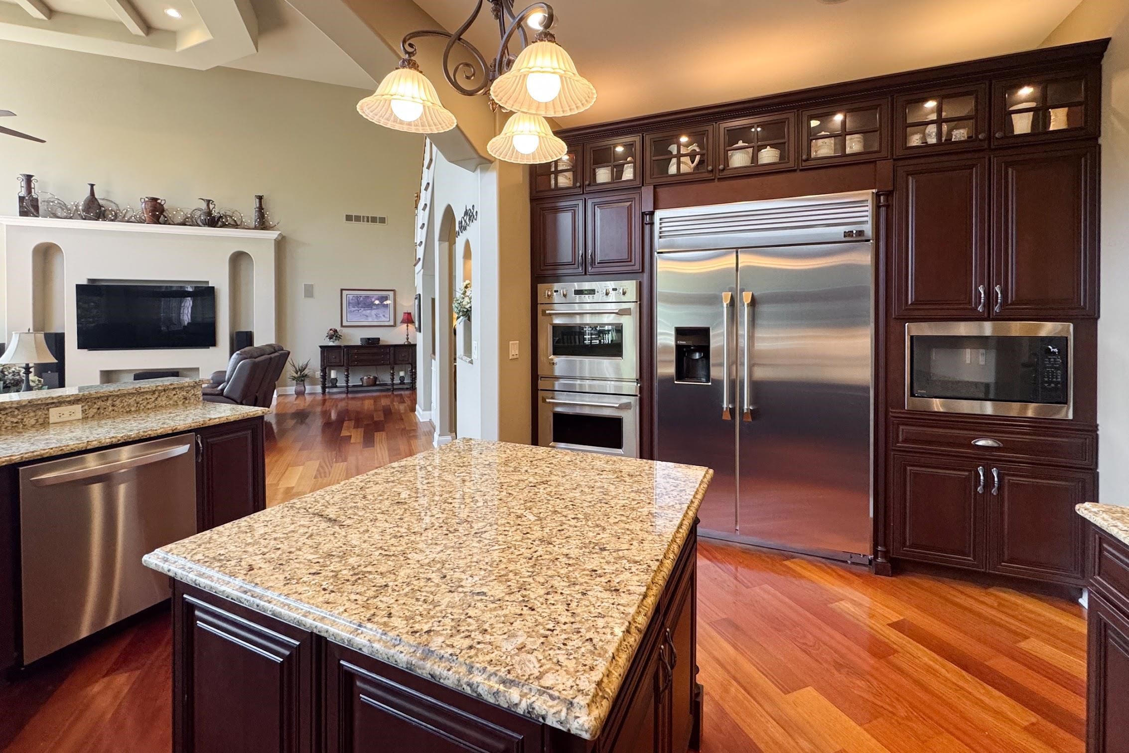 163 Russell Road Oregon, IL 61061 - Photo 22 of 64 a kitchen with stainless steel appliances kitchen island granite countertop a refrigerator a stove and a sink with wooden floor