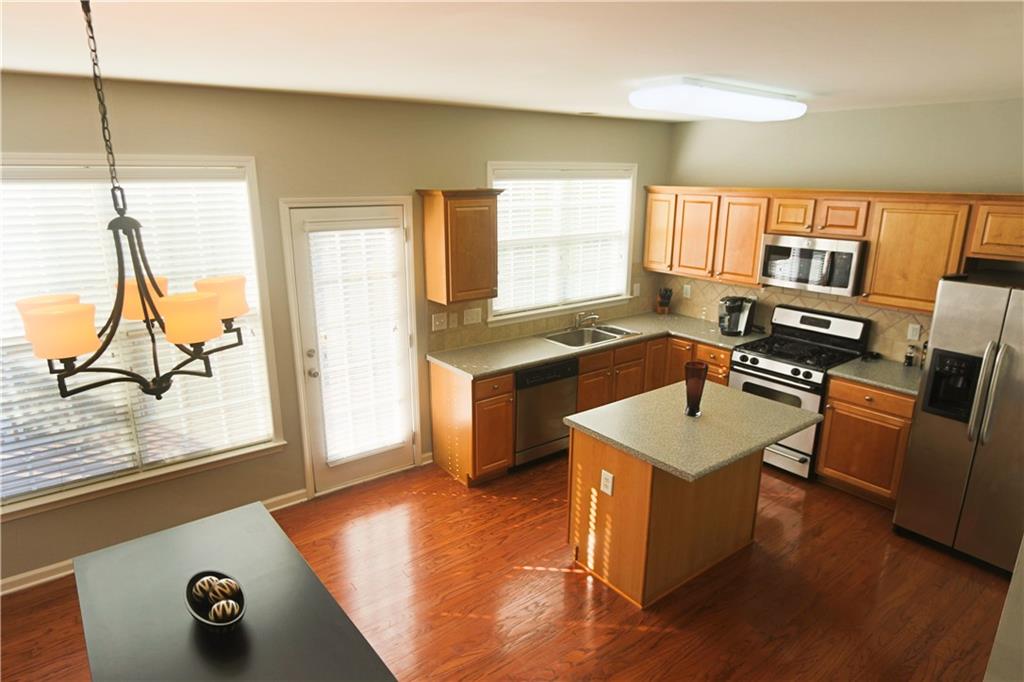 1035 Thornborough Drive Alpharetta, GA 30004 - Photo 1 of 14 a kitchen that has a sink a stove and a table in it