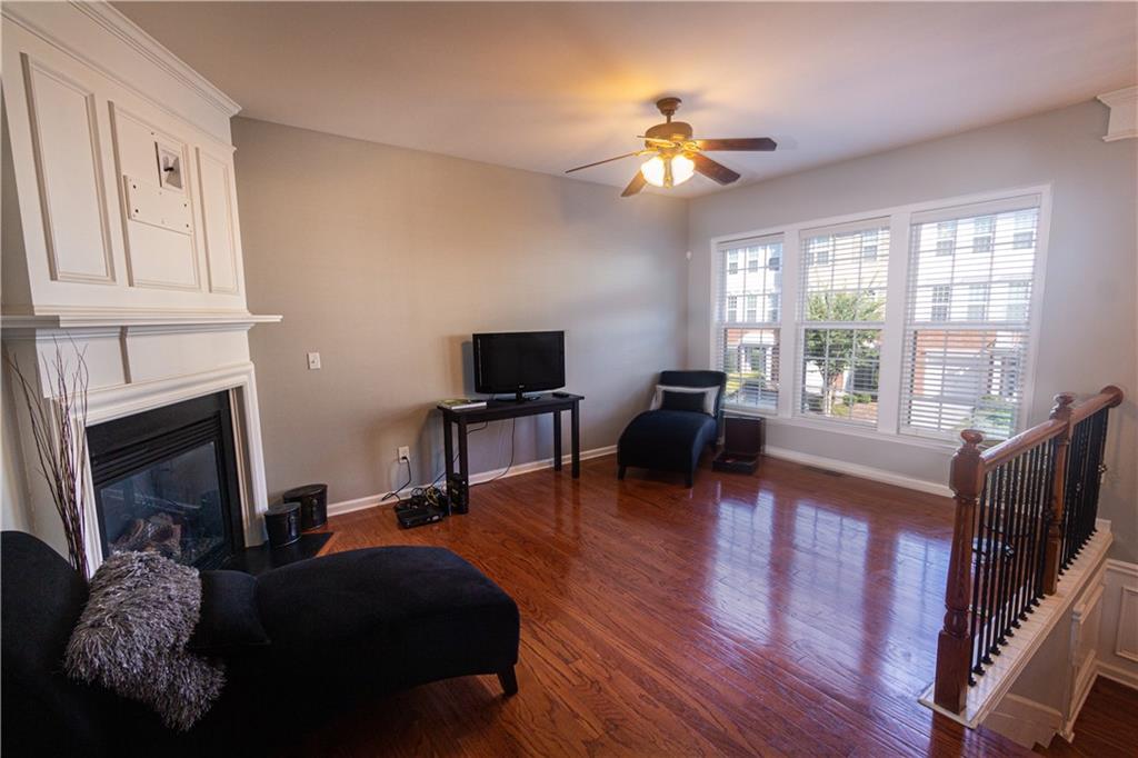 1035 Thornborough Drive Alpharetta, GA 30004 - Photo 4 of 14 a living room with furniture a fireplace and a flat screen tv