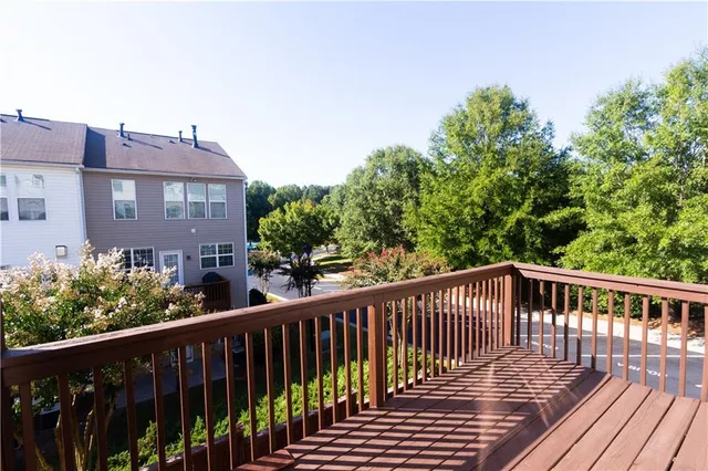 a view of a brick house with a wooden deck