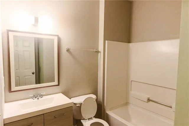 a bathroom with a sink mirror toilet and shower