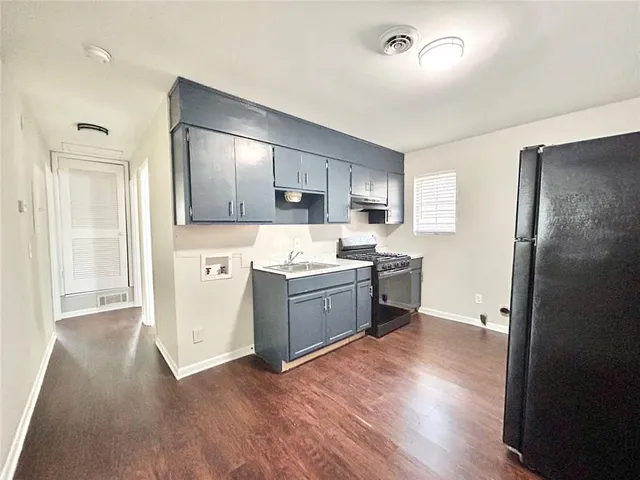 a kitchen with a refrigerator and a stove top oven