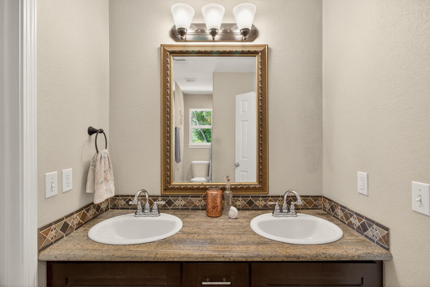 6332 Horseshoe Bar Road Loomis, CA 95650 - Photo 27 of 85 Dual sink vanity featuring a granite-style countertop and dark wood-finish cabinetry