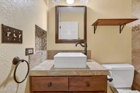 a bathroom with a granite countertop sink a toilet and mirror