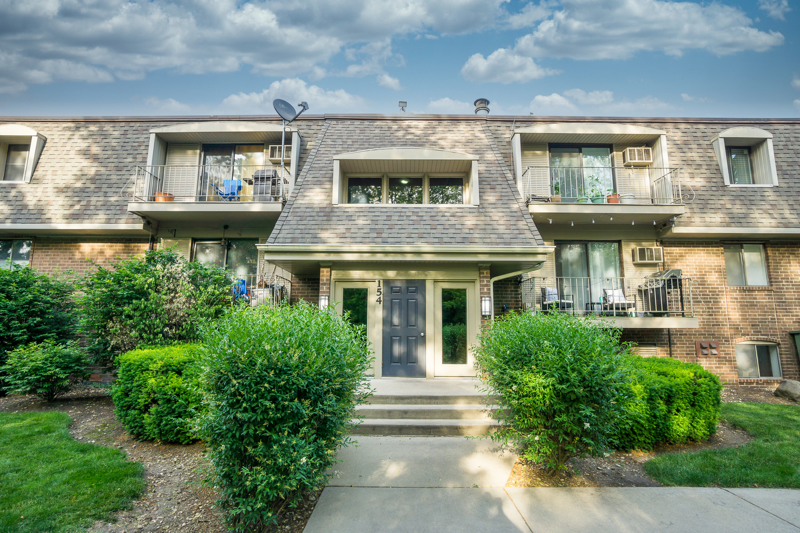 154 East Bailey Road, Unit A Naperville, IL 60565 - Photo 1 of 9 a front view of a house with a garden