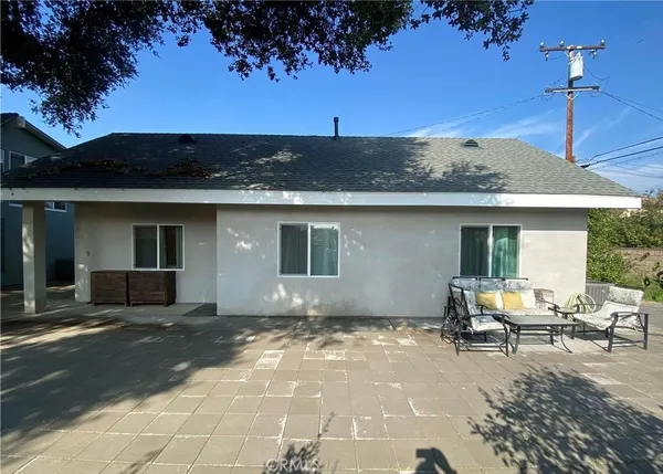a view of a house with backyard sitting area and garden