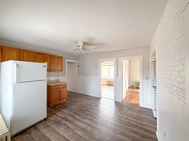 a view of a kitchen with refrigerator and wooden floor