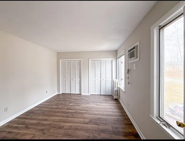 a view of a room with wooden floor and windows
