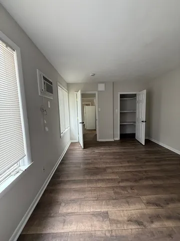 a view of empty room with wooden floor
