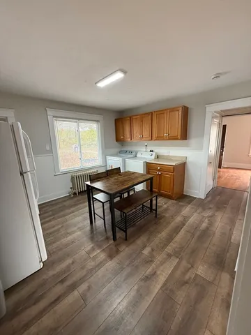 a living room with stainless steel appliances granite countertop furniture wooden floor and a window