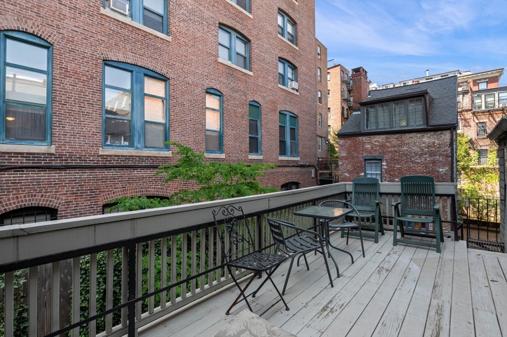 36 Joy Street, Unit F2 Boston, MA 02114 - Photo 13 of 17 a balcony of a house with wooden floor outdoor seating and yard in the back