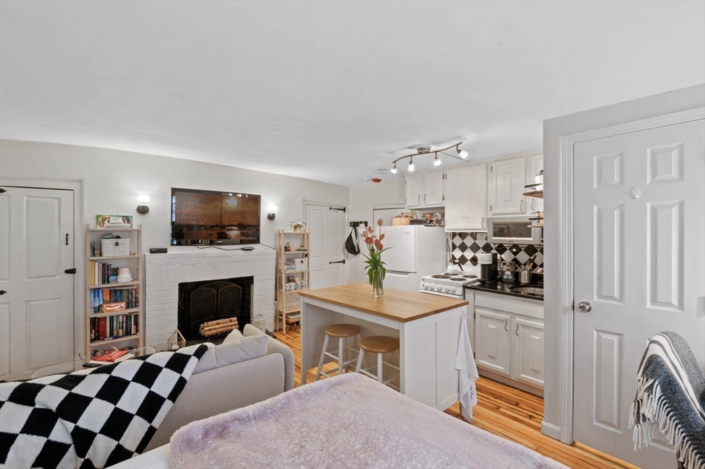 36 Joy Street, Unit F2 Boston, MA 02114 - Photo 6 of 17 a living room with furniture a flat screen tv and a fireplace