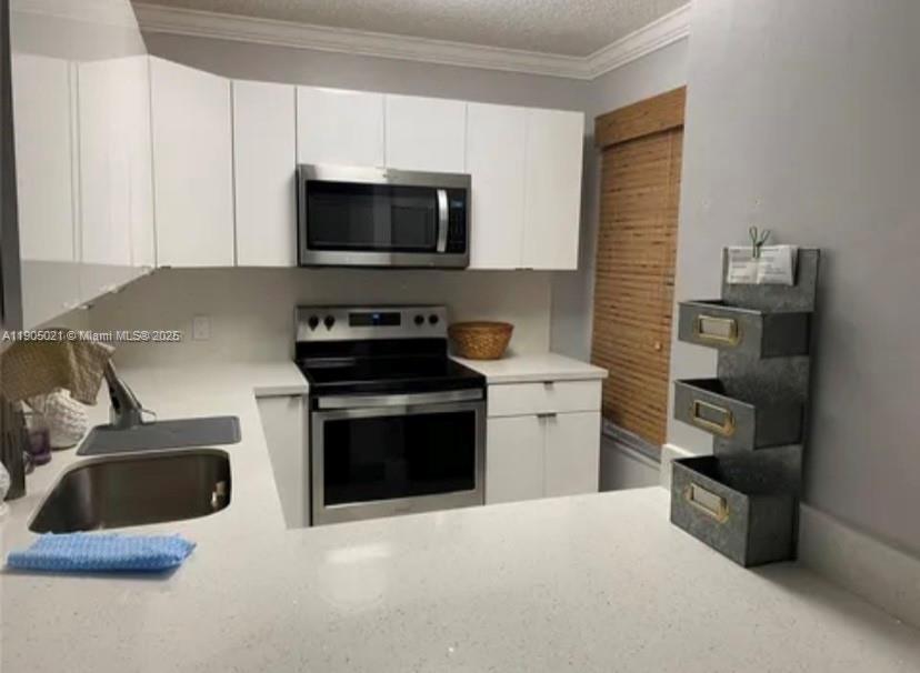 13781 Southwest 66th Street, Unit 229B Miami, FL 33183 - Photo 2 of 6 a kitchen with a stove and a microwave