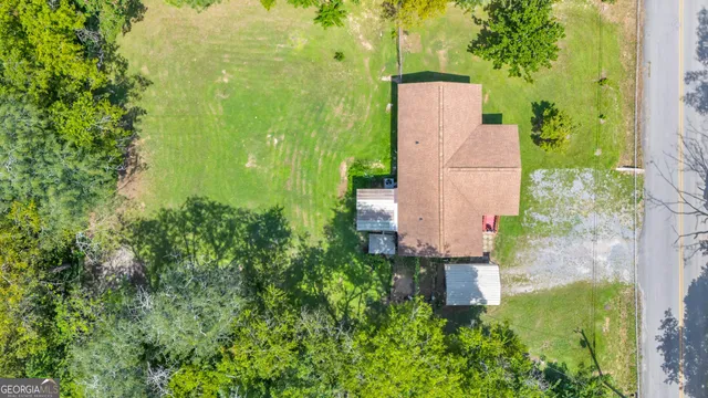 an aerial view of a house with a yard and large trees