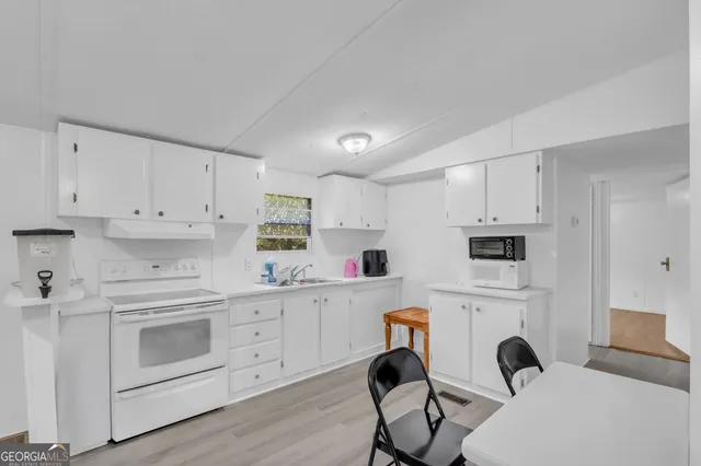 a kitchen with white cabinets and white appliances