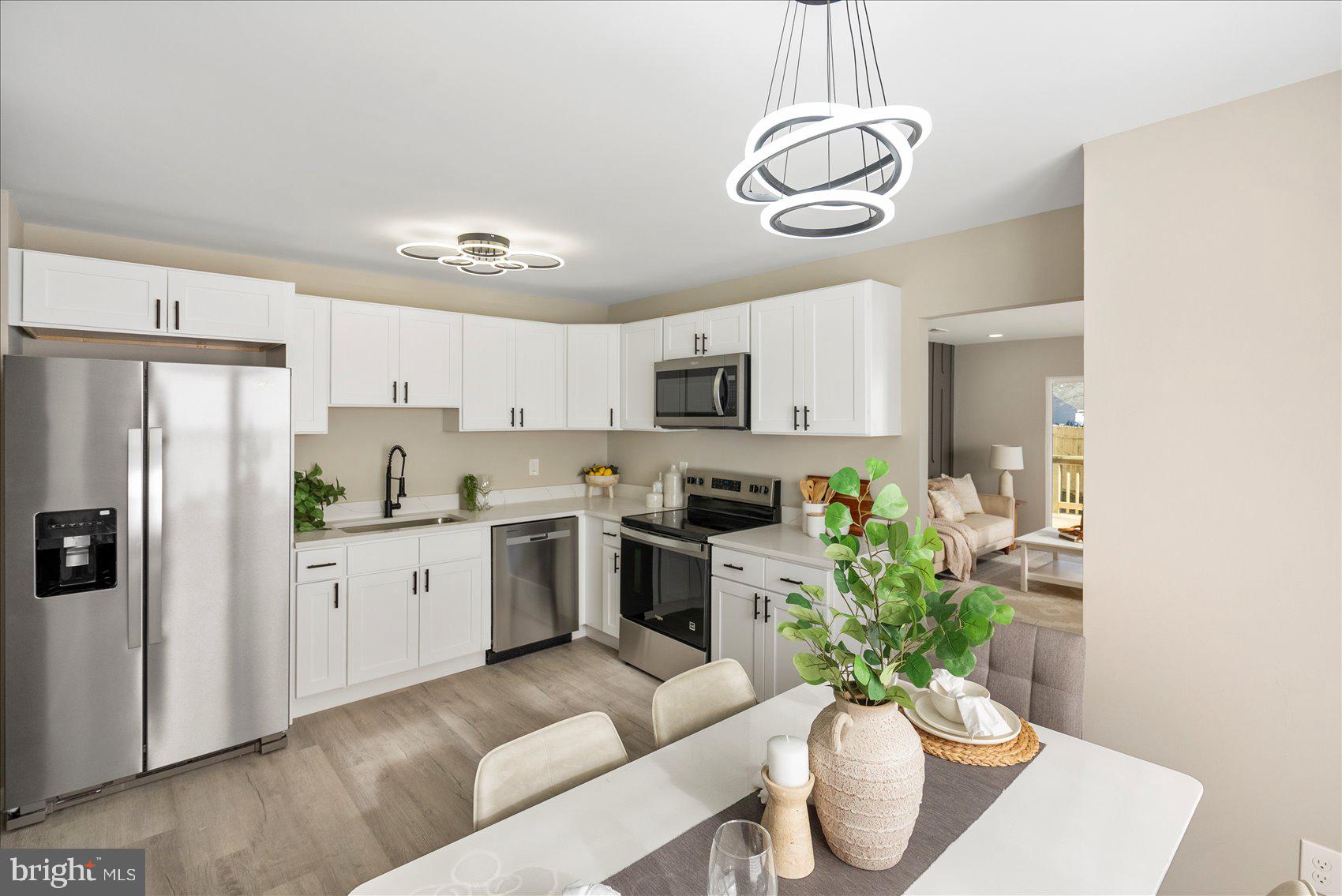3466 Albantowne Way Edgewood, MD 21040 - Photo 14 of 36 a kitchen with stainless steel appliances a white table a refrigerator a stove a microwave and cabinets